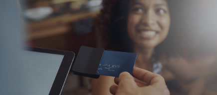 photo of young woman smiling as her credit card purchase is being processed