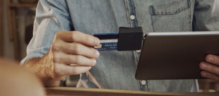 photo of older hands using an ipod and attachment to process a credit card transaction