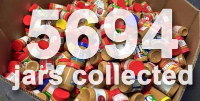 Collection bin of peanut butter with 5,694 jars collected written across the photo.