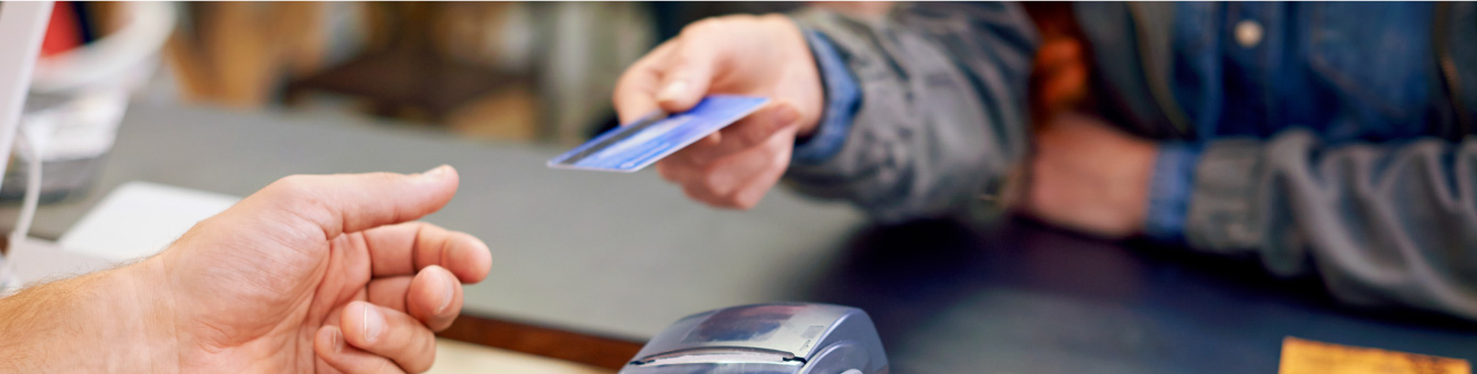 merchant handing over credit card for purchase