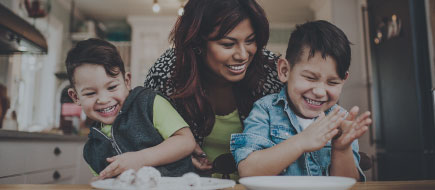 photo of a mom with two young boys preparing food in the kitchen